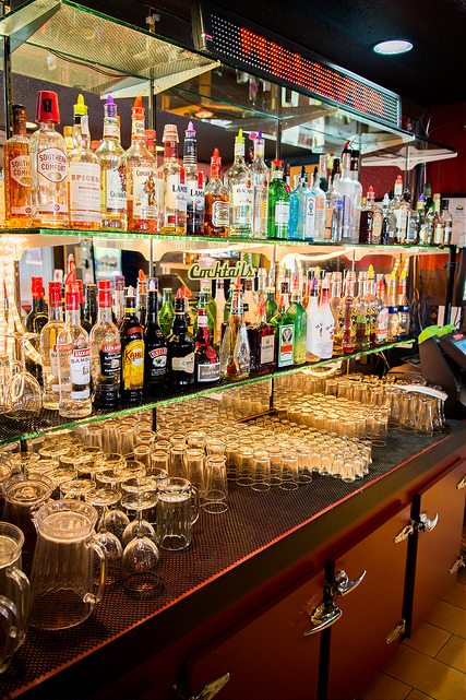 The back bar at Daddy Cool's, shelves stacked with bottles and glasses under the lights