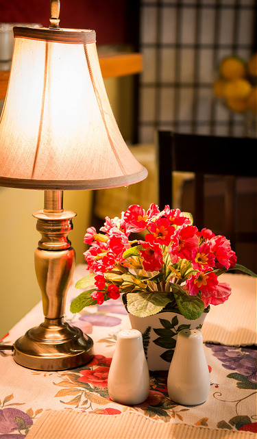 Lamp and flowers on a set table in the dining room