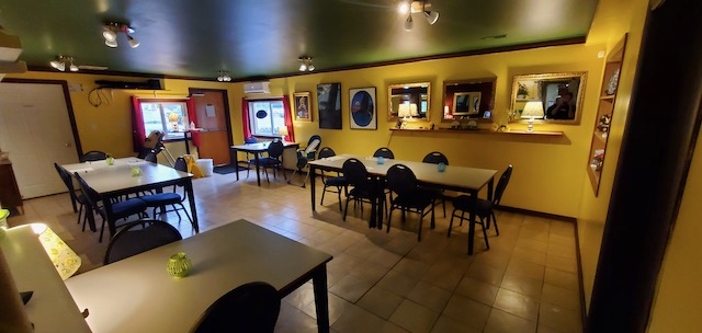 The Mile Zero Dining Room: bright yellow walls, set tables and lamplit sideboard